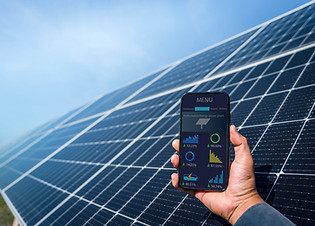 Man hand holding the telephone for monitoring performance in solar power plant(solar cell)